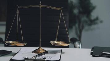 Business and lawyers discussing contract papers with brass scale on desk in office. Law, legal services, advice, justice and law concept picture with film grain effect video