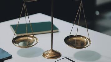 Business and lawyers discussing contract papers with brass scale on desk in office. Law, legal services, advice, justice and law concept picture with film grain effect video