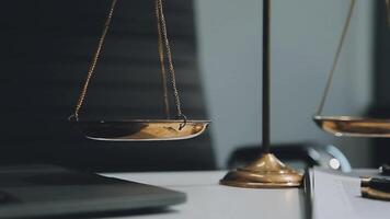 Business and lawyers discussing contract papers with brass scale on desk in office. Law, legal services, advice, justice and law concept picture with film grain effect video