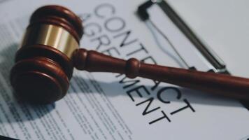 Business and lawyers discussing contract papers with brass scale on desk in office. Law, legal services, advice, justice and law concept picture with film grain effect video