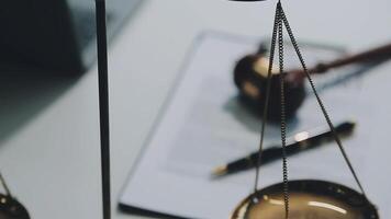 Business and lawyers discussing contract papers with brass scale on desk in office. Law, legal services, advice, justice and law concept picture with film grain effect video