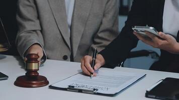 zaken en advocaten bespreken contractpapieren met koperen schaal op bureau in kantoor. wet, juridische diensten, advies, rechtvaardigheid en wet concept foto met film grain effect video