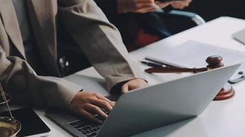 Business and lawyers discussing contract papers with brass scale on desk in office. Law, legal services, advice, justice and law concept picture with film grain effect video