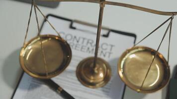 Business and lawyers discussing contract papers with brass scale on desk in office. Law, legal services, advice, justice and law concept picture with film grain effect video