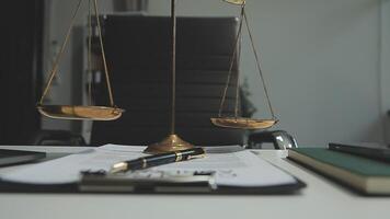 Business and lawyers discussing contract papers with brass scale on desk in office. Law, legal services, advice, justice and law concept picture with film grain effect video