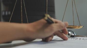 Business and lawyers discussing contract papers with brass scale on desk in office. Law, legal services, advice, justice and law concept picture with film grain effect video