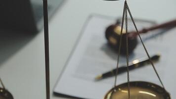 Business and lawyers discussing contract papers with brass scale on desk in office. Law, legal services, advice, justice and law concept picture with film grain effect video