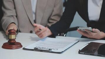 zaken en advocaten bespreken contractpapieren met koperen schaal op bureau in kantoor. wet, juridische diensten, advies, rechtvaardigheid en wet concept foto met film grain effect video