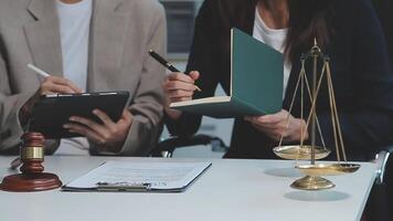 Business and lawyers discussing contract papers with brass scale on desk in office. Law, legal services, advice, justice and law concept picture with film grain effect video