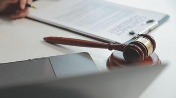 Business and lawyers discussing contract papers with brass scale on desk in office. Law, legal services, advice, justice and law concept picture with film grain effect video