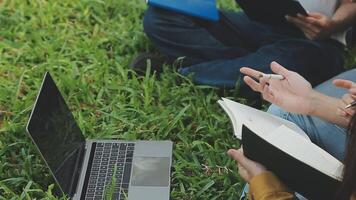 groep van gelukkig jong Aziatisch college studenten zittend Aan een bank, op zoek Bij een laptop scherm, bespreken en brainstorming Aan hun school- project samen. video