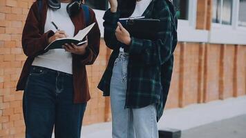 grupo do jovem ásia aluna caminhando e falando às universidade antes classe sala. Educação, costas para escola conceito video