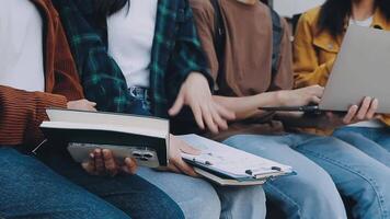 grupp av Lycklig ung asiatisk högskola studenter Sammanträde på en bänk, ser på en bärbar dator skärm, diskuterar och brainstorming på deras skola projekt tillsammans. video