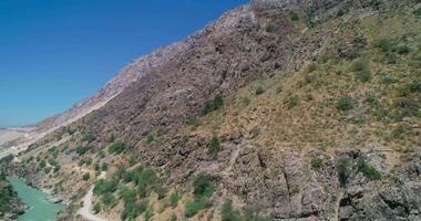 The drone flies on the river on a cloudless day, surrounded by mountains video