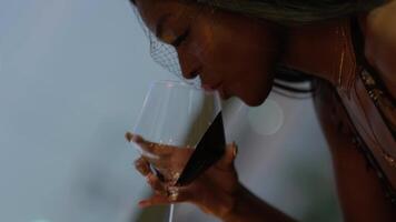 jovem moreno mulher com grandes Preto cabelo dentro tarde vestir bebendo vinho às uma mesa dentro uma restaurante video