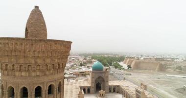 ein Drohne fliegt um das berühmt Denkmal Komplex kalyan Poi Kalon Komplex und Poi Kalon Minarett, Poi Kalan oder po-i-kalyan im Buchara beim Dämmerung video