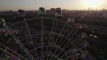 A drone flies over an amusement park with carousels and a Ferris wheel video