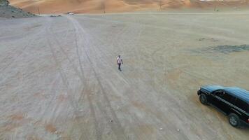 A drone flies over a man walking on an empty road video