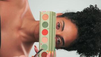 Professional make-up master applies paint to a young model with curly hair video