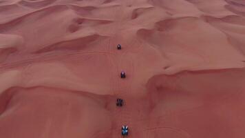 A drone flies over quad bikes driving through the sand dunes of the desert in the United Arab Emirates video