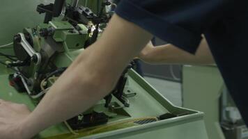 A young man works at a machine in the workshop video