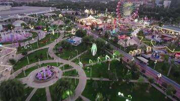 een dar vliegt over- een amusement park met draaimolens en een ferris wiel video