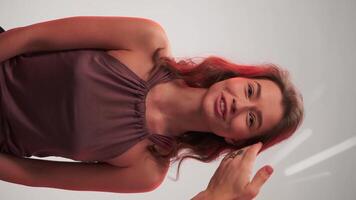 Young woman styling her hair with the help of a master in the studio before shooting video