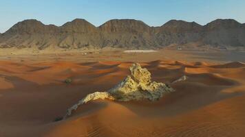 Drone around a lonely rock among the sandy desert video