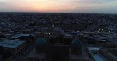 een dar vliegt over- de oud stad en de beroemd gedenkteken complex ikalyan poi kalon complex en poi kalon minaret n bukhara Bij dageraad video