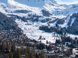 Aerial View of Snow Covered Verbier, Swiss Alps with Ski Trails and Chalets photo