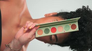 professionnel maquillage Maître s'applique peindre à une Jeune modèle avec frisé cheveux video