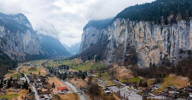 Aerial View of Murren, Switzerland  Alpine Town Amidst Rugged Cliffs and Misty Mountains photo