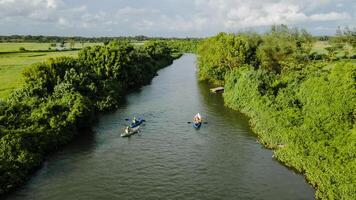 aerial view, you can see a person rowing in a canoe at the mouth of the river. photo