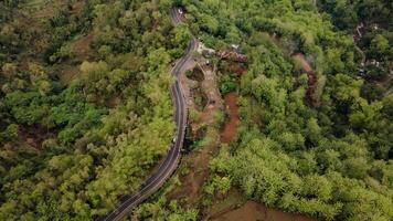 aerial view, asphalt road winding through forest and countryside. photo