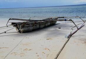 small boat on the beach, on white sand photo