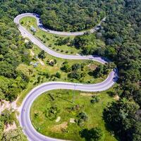 Aerial view of cars are going through a curve  road on the mountain photo