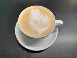 White cup with coffee. Coffee in a white cup on a black background photo