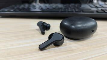 black cordless earphones connected to a computer device photo