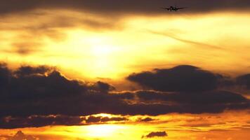 reclame vlak naderen landen. pittoreske zonsondergang, vlak in de lucht. vliegtuig silhouet tegen wolken. toerisme en reizen concept video