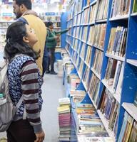 nuevo Delhi, India, febrero 17 2024 - variedad de libros en estante dentro un puesto de libros a Delhi internacional libro justo, selección de libros en monitor en anual libro justa a bharat mandapam complejo foto