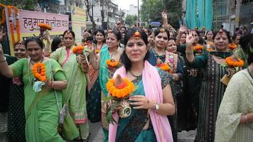 nieuw Delhi, Indië maart 25 2024 - Dames met kalash Aan hoofd gedurende jagannath tempel mangal kalash jatra, Indisch Hindoe toegewijden dragen aarden potten met heilig water met een kokosnoot Aan top video