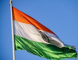 India flag flying high at Connaught Place with pride in blue sky, India flag fluttering, Indian Flag on Independence Day and Republic Day of India, tilt up shot, Waving Indian flag, Har Ghar Tiranga photo