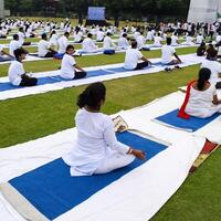 New Delhi, India, June 21, 2023 - Group Yoga exercise session for people at Yamuna Sports Complex in Delhi on International Yoga Day, Big group of adults attending yoga class in cricket stadium photo