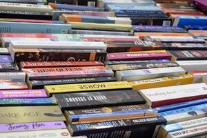 New Delhi, India, February 17 2024 - Variety of Books on shelf inside a book-stall at Delhi International Book Fair, Selection of books on display in Annual Book Fair at Bharat Mandapam complex photo