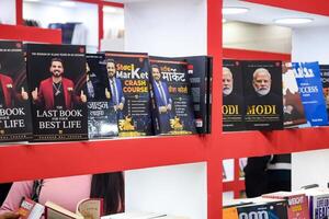 New Delhi, India, February 17 2024 - Variety of Books on shelf inside a book-stall at Delhi International Book Fair, Selection of books on display in Annual Book Fair at Bharat Mandapam complex photo