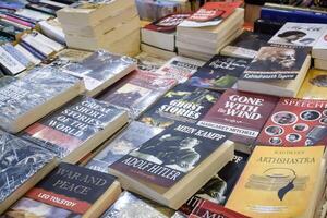 New Delhi, India, February 17 2024 - Variety of Books on shelf inside a book-stall at Delhi International Book Fair, Selection of books on display in Annual Book Fair at Bharat Mandapam complex photo