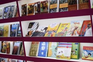 New Delhi, India, February 17 2024 - Variety of Books on shelf inside a book-stall at Delhi International Book Fair, Selection of books on display in Annual Book Fair at Bharat Mandapam complex photo