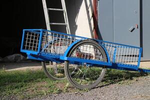 empty cargo cart, bicycle trailer, spoked bicycle wheels, road rural summer landscape photo