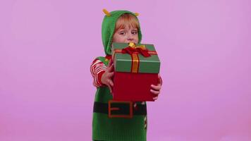 Funny teen toddler girl kid in Christmas Santa costume presenting Christmas gift box, shopping sale video