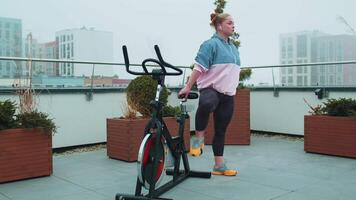 Woman performs aerobic endurance training workout cardio routine on the simulators, cycle training video